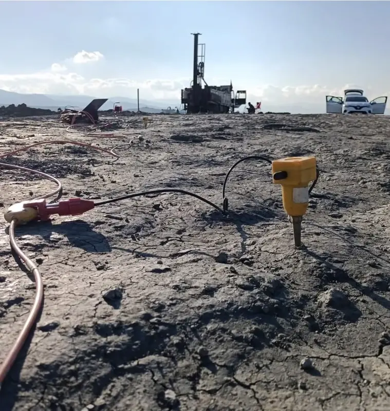 Sismik ölçüm jeofonu ve arka planda sondaj kulesi