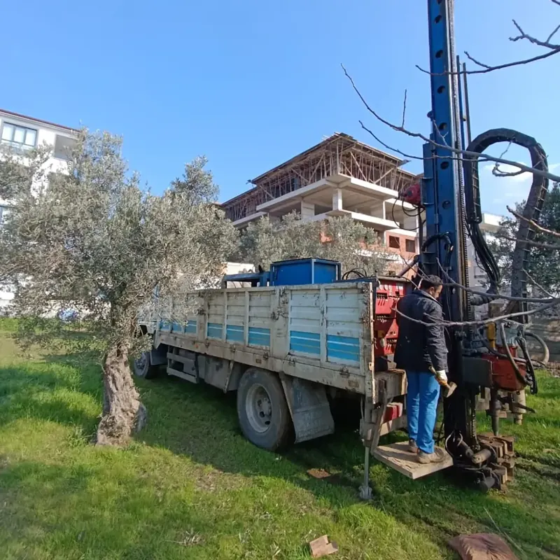Konut inşaatı yanında parsel içinde çalışan kamyona monte sondaj makinesi
